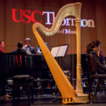 Photo of a harp on stage at a classical concert hall.