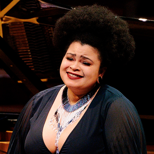 Vocalist Jasmin White performing an opera on stage in concert attire.