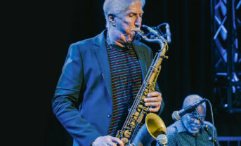 A saxophone player performs on stage.