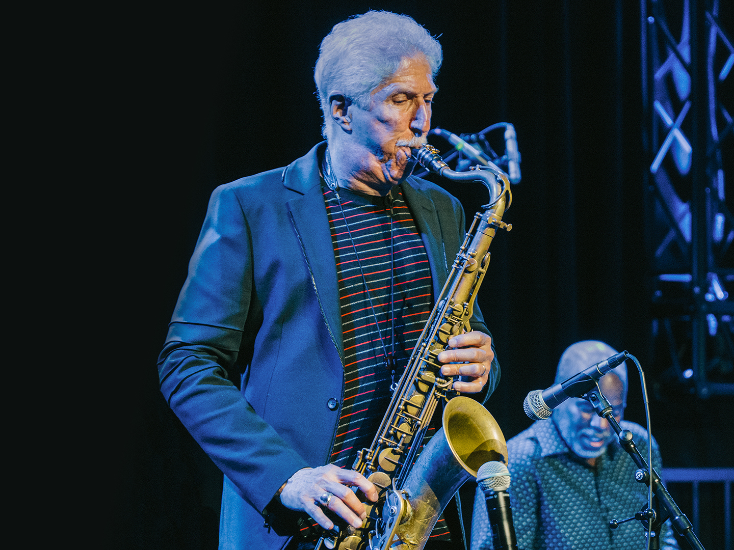 A saxophone player performs on stage. 