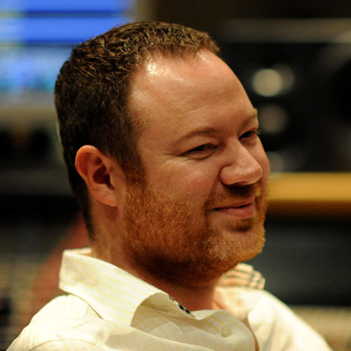 Recording engineer Casey Stone smiling in a sound studio.