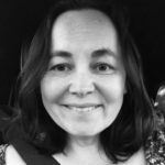 Music scholar and educator Beatriz Ilari smiling into the camera in black and white.