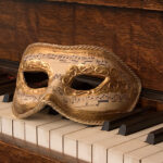 A baroque mask on an early music piano.