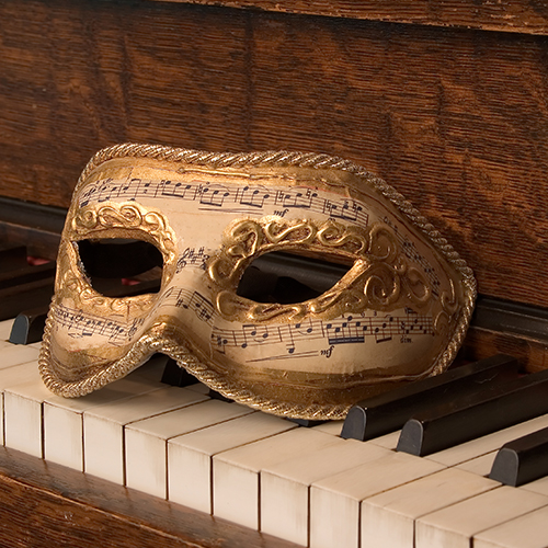 A baroque mask on an early music piano.