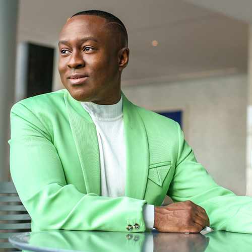 Jason King dressed in a green blazer and smiling.