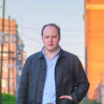 Dan Caputo wearing a gray jacket standing in a street