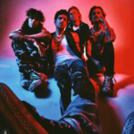 Photo of the band Amber Wild sitting in blue and red light.
