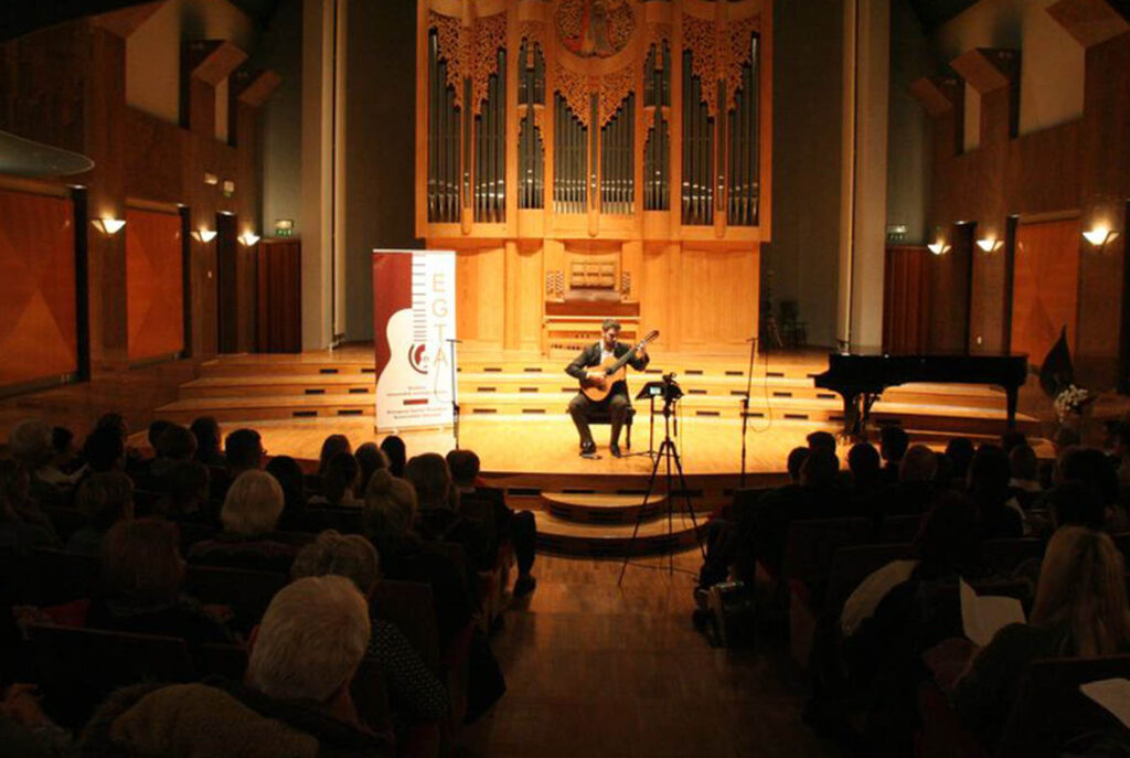 A classical guitarist performs in a church.