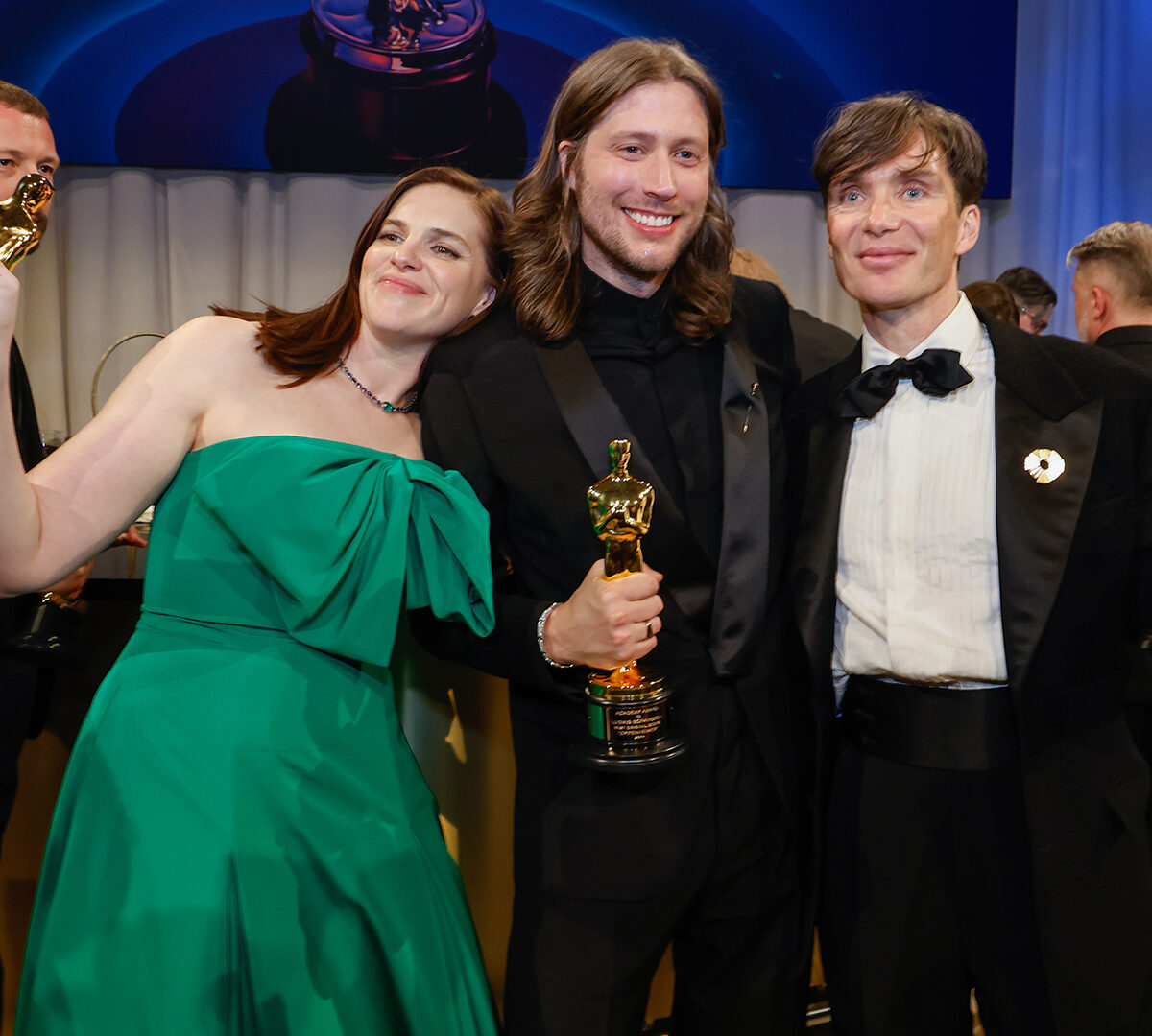 Oscar-winning composer Ludwig Göransson with Jennifer Lame and Cillian Murphy at the 96th Annual Academy Awards Governor's Ball, all holding Academy Award statuettes.