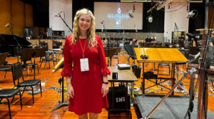 Composer and conductor Oliviana Marie on the sound stage of an orchestral screen scoring session at a film studio.