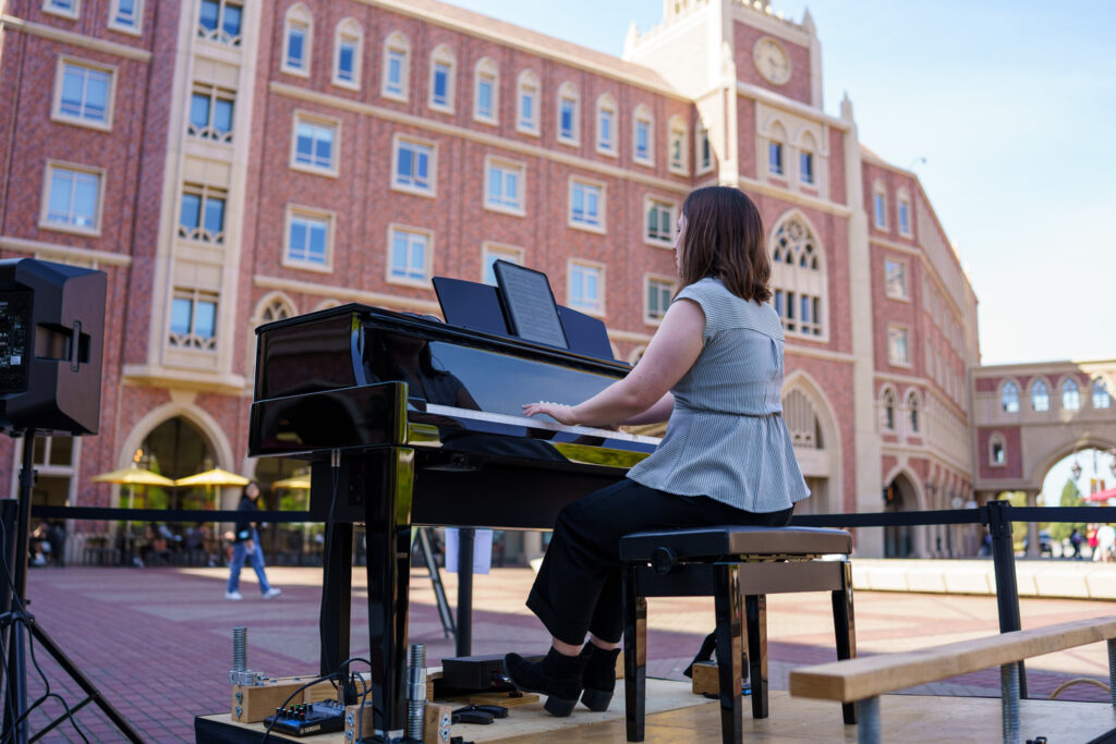 Photo of a pianist performing outdoors.