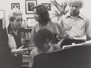 A black and white photo of a piano classroom at a college in the 1980s.