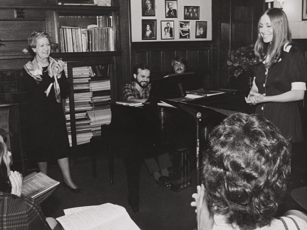 A black and white photo of a piano classroom at a college in the 1980s.