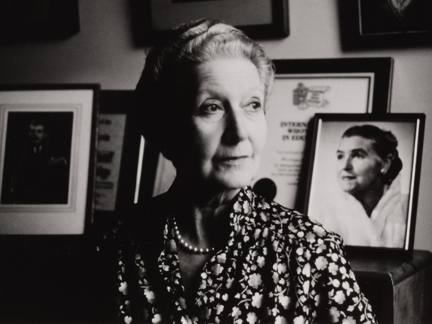 Black and white photo of a pianist looking off to the side in their office. 