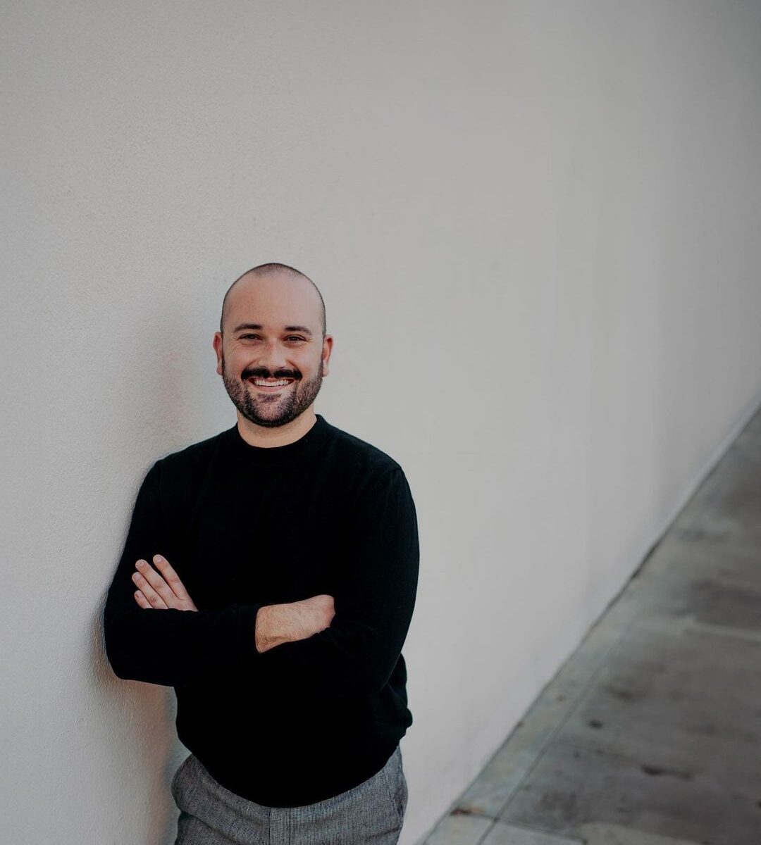 Connor Scott poses against an off-white wall.