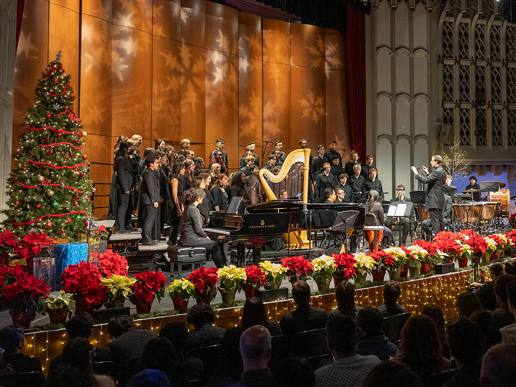 Choristers perform with accompaniment, led by a conductor.