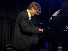 A student pianist performs on stage.