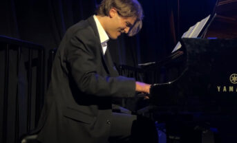 Photo of a student pianist performing on stage.