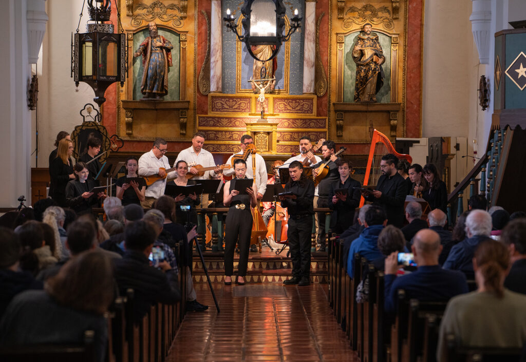 A music ensemble performs indoors at a church.