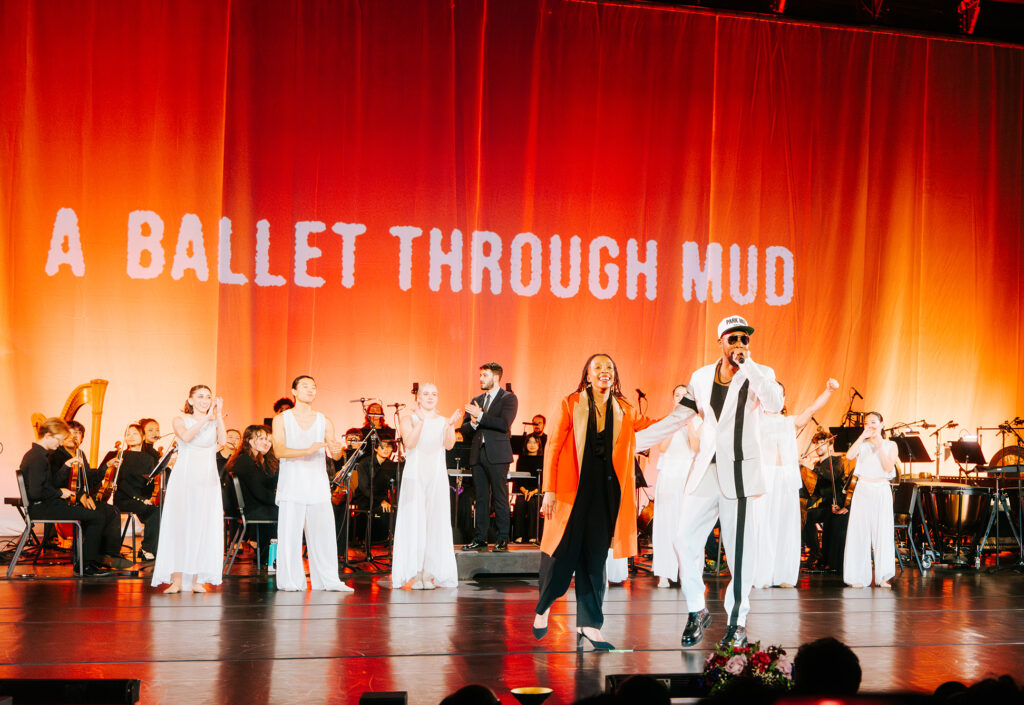 A group of performers on stage during a curtain call.