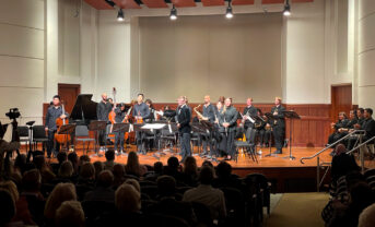 A classical music ensemble takes a bow on stage.