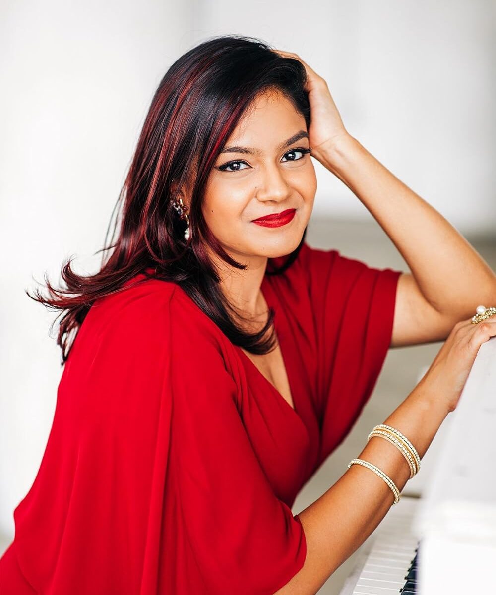Composer Raashi Kulkarni poses in red.