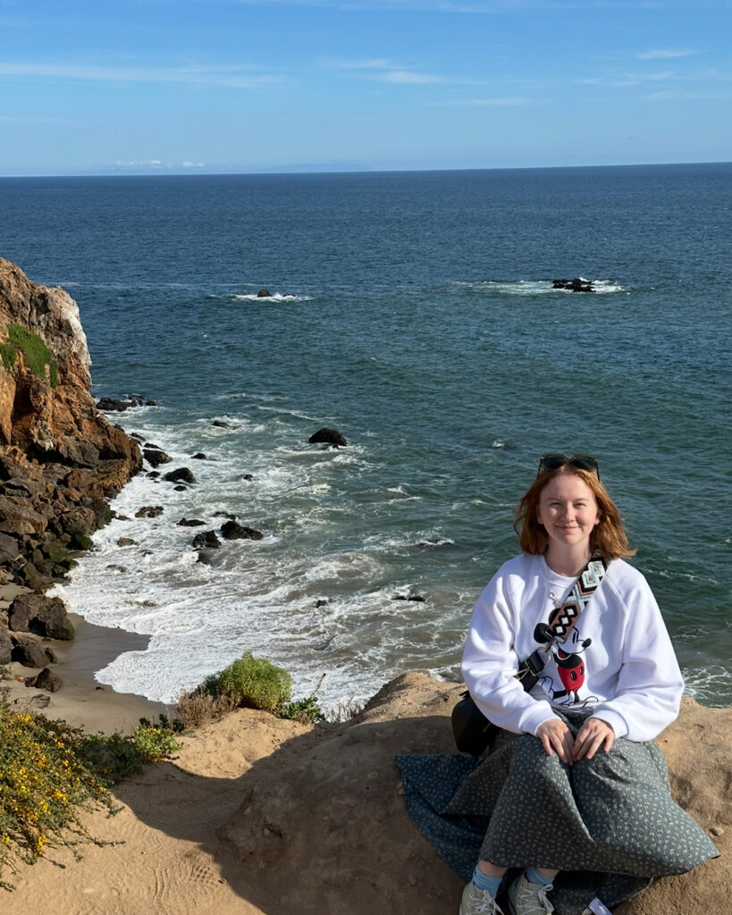 Ella Kaale seated with the ocean in the background.