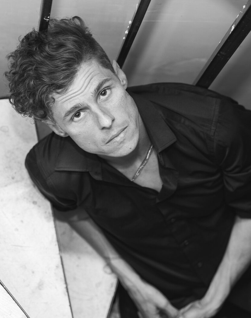 Sklar Funk seated on a staircase, looking up into the camera.