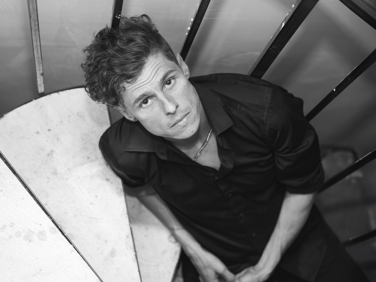 Sklar Funk seated on a staircase, looking up into the camera.