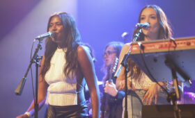 Two singers harmonize onstage.