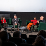 quartet of panelists conversing on plush couches