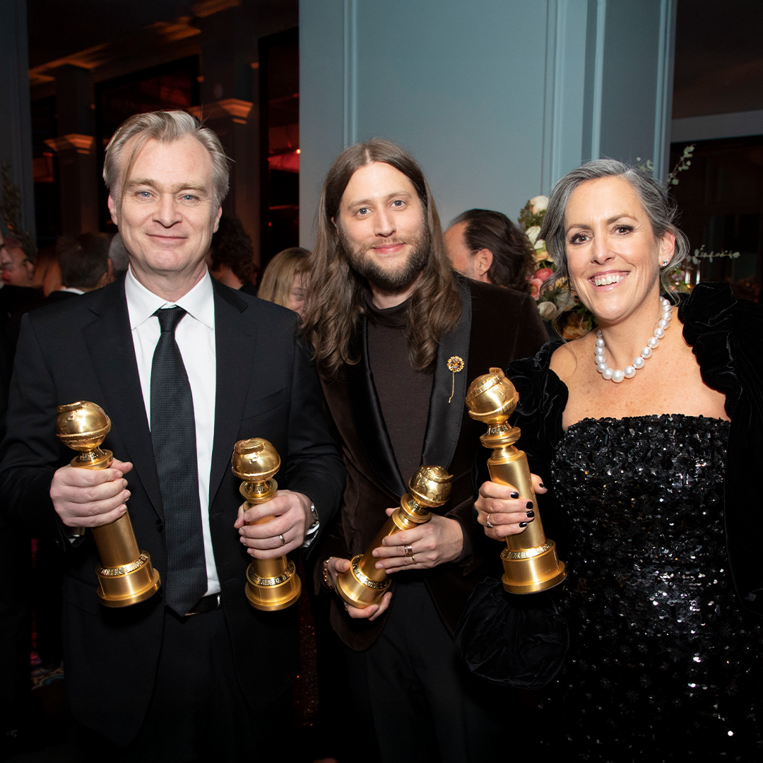 Photo of director Christopher Nolan, composer Ludwig Göransson and producer Emma Thomas holding Golden Globe awards as they attend a post-show party reception.
