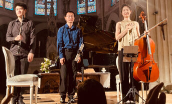 A photo of USC Thornton's Ivory Trio taking a bow inside of a church in France.