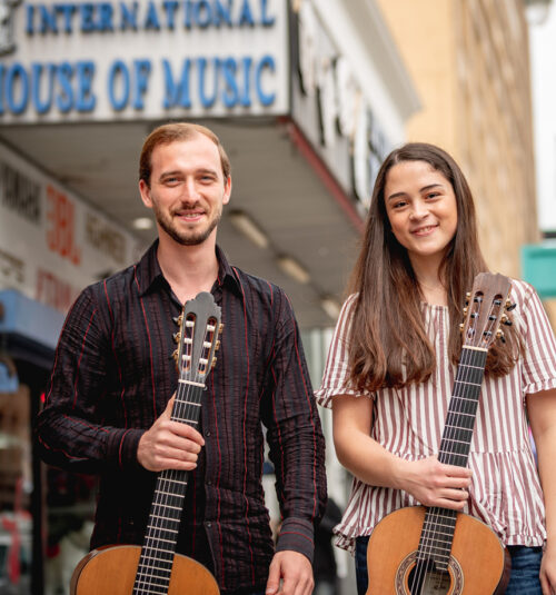 Two students holding classical guitars in downtown Los Angeles.