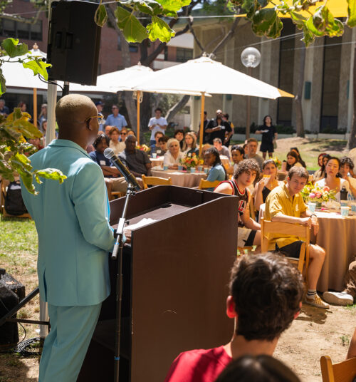 Dean Jason King addresses students of the USC Thornton School of Music outside underneath a colorful tent.