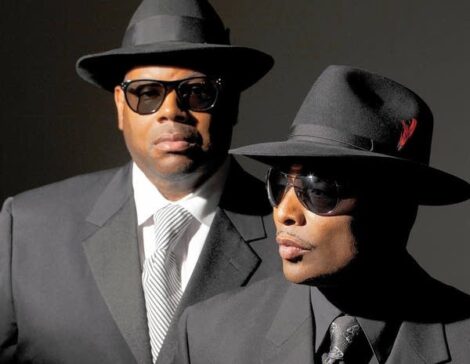 Jimmy Jam and Terry Lewis wearing black suits and fedoras.