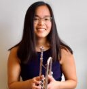 Headshot of Amy Millesen, holding a trumpet.
