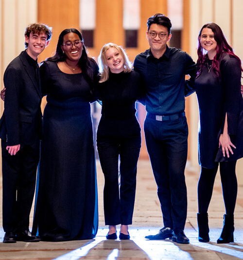 Group of choral singers pose for a photo.