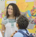 Image of a teacher talking with a group of elementary students.