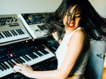 Photo of Karina DePiano playing the keyboard indoors.
