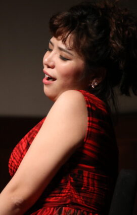 An opera singer performs on stage.