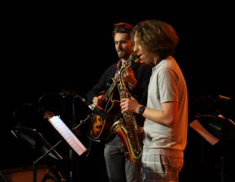 Jazz students perform on guitar, saxophone, and bass.