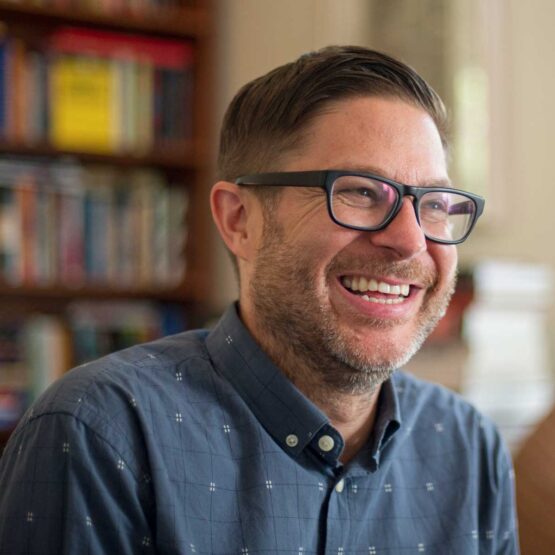 Image of man with glasses smiling.