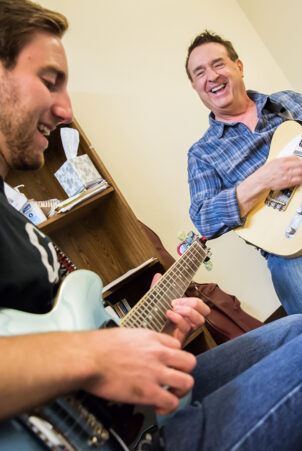 Instructor and student perform on electric guitars.