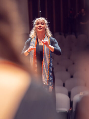 A teaching assistant leads the choir.