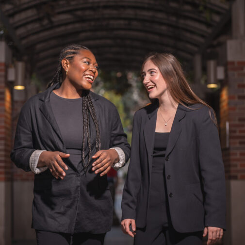 Two choristers talk on a brick path
