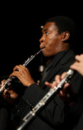 USC Thornton classical winds music students performing on stage in concert attire.